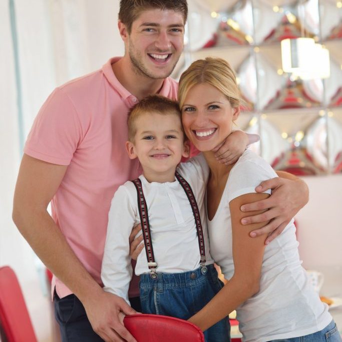 happy young family with kids in bright modern living room have fun and looking big flat lcd tv